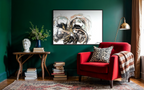 Unfold on a deep green wall above a side table, beside a red armchair