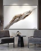 Bedrock above two grey armchairs and a round black side table in a calm interior.