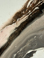 Close-up of Bedrock showing rough sand texture with scattered gold flecks across brown, grey and cream.