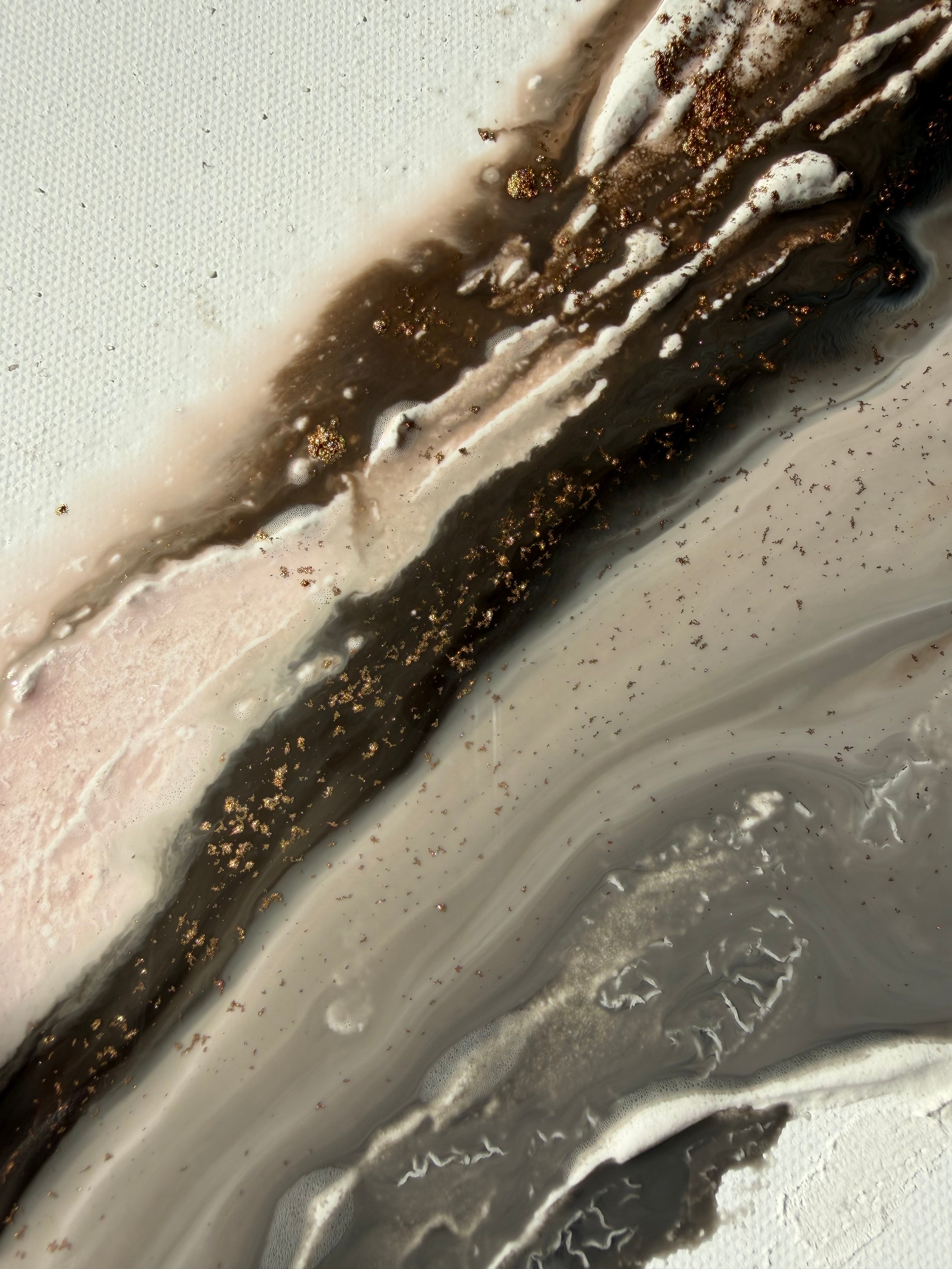 Close-up of Bedrock showing rough sand texture with scattered gold flecks across brown, grey and cream.