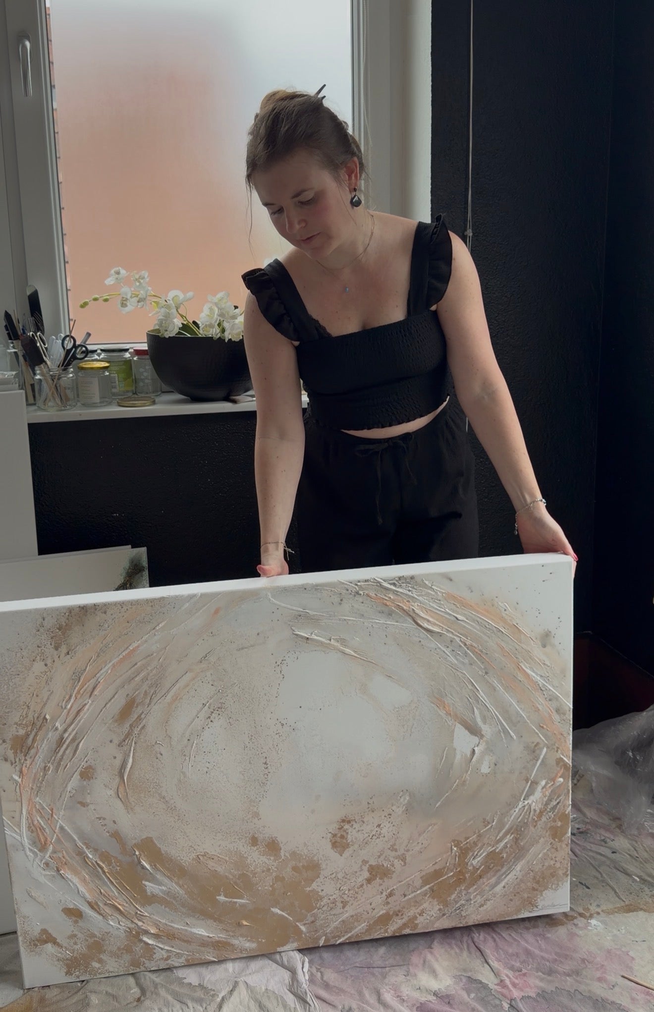 Stefanie Carola holding the original painting Peace in her Vienna studio