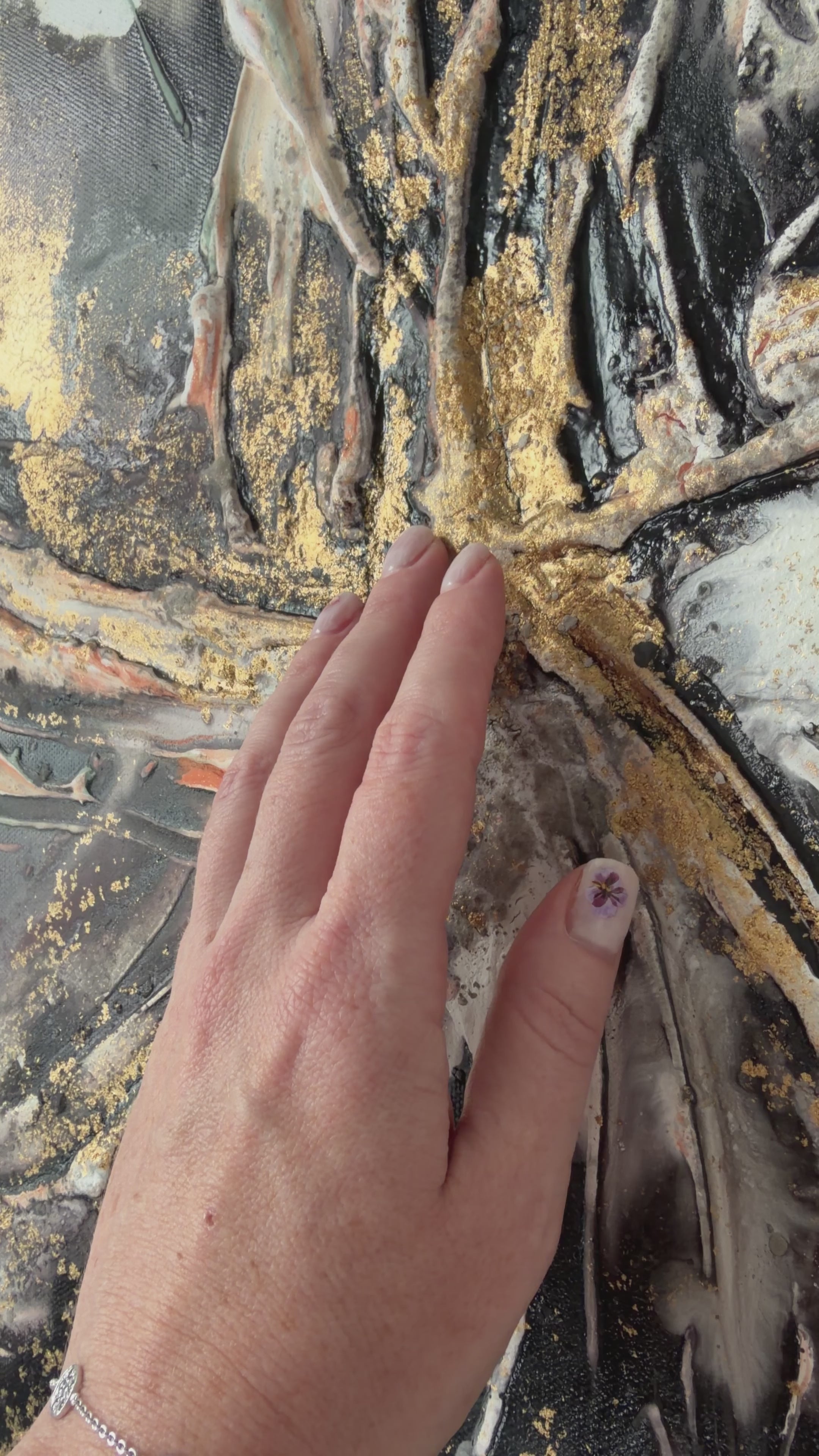 Video of a hand moving across the gold and black texture of Unfold