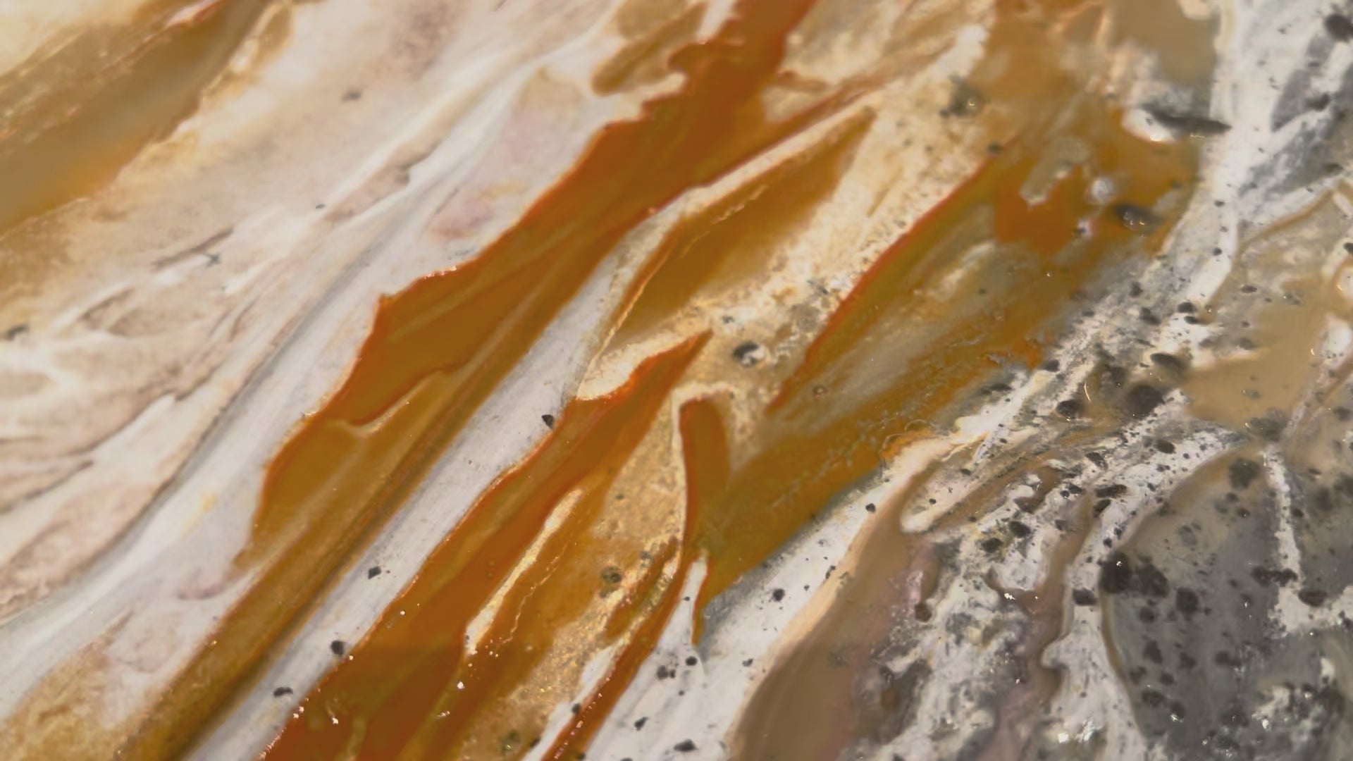 Video close-up of gold pigment moving over the textured surface of Serenity 2